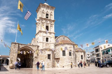 Larnaca, Kıbrıs - 16 Nisan 2022: Saint Lazarus Kilisesi önünde yürüyen turistler.