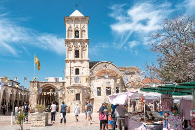 Larnaca, Kıbrıs - 16 Nisan 2022: Saint Lazarus Kilisesi önünde yürüyen turistler