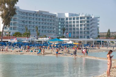 Ayia Napa, Kıbrıs - 21 Nisan 2018: Ayia Napa yakınlarındaki Nissi plajında güneşli bir günün tadını çıkaran turistler