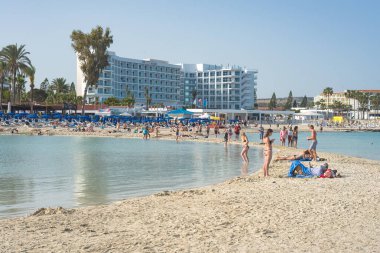 Ayia Napa, Kıbrıs - 21 Nisan 2018: Kıbrıs Rum Kesimi 'nin Ayia Napa kentindeki Nissi plajında güneşli bir günün tadını çıkaran turistler