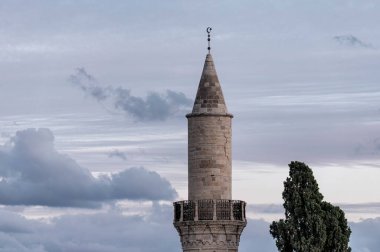 Minaret of Djami Kebir Mosque standing tall under a cloudy sky. Larnaca, Cyprus clipart