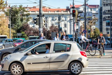 Belgrad, Sırbistan - 20 Eylül 2019: Sırbistan 'ın başkenti Belgrad' da güneşli bir günde arabalar, bisikletçiler ve yayalar yaya geçidinde bekliyorlar