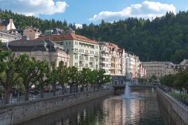 Karlovy Vary, Çek Cumhuriyeti - 26 Mayıs 2017: Tepla Nehri güneşli bir günde gezen insanlar ve renkli binaları ile Çek Cumhuriyeti 'nin Karlovy Vary kentindeki kaplıca kasabasından akıyor