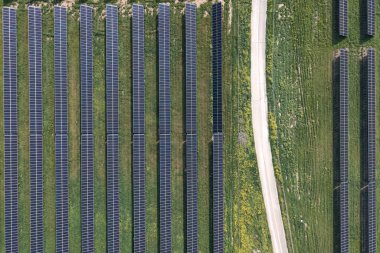 Birçok güneş panelinin hava görüntüsü temiz enerji üretmek için güneş ışığını yakalıyor. Agios Sozomenos, Kıbrıs