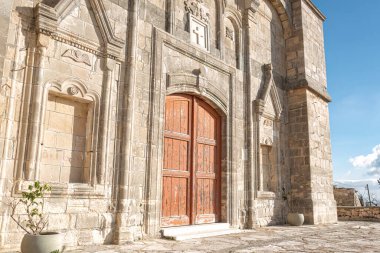 The Timios Prodromos church in Vouni village features beautiful stonework and a large wooden door. Limassol District, Cyprus clipart