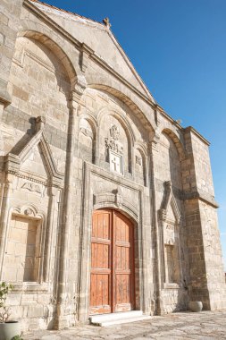 The Timios Prodromos church in Vouni village, Limassol District, Cyprus is displaying its weathered wooden doors on a sunny day clipart