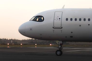 İniş pistinde büyük yolcu uçağı ve kokpitinde bir pilot.