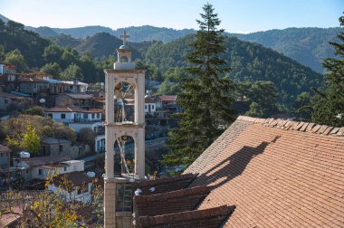 Başmelek Mikail Kilisesi 'nin çan kulesi, Kıbrıs' ın Troodos dağlarında yer alan Platanistasa köyünün geleneksel evlerinin üzerinde yükselir. Lefkoşe Bölgesi
