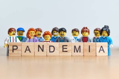 Bir grup endişeli lego insan Scrabble Fayans 'ın arkasında pandemik yazıyorlar. İllüstrasyon başyazısı. 20 Ocak 2025