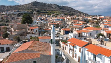 Kiril 'deki Pano lefkara köyünün cazibesini yakalıyor, geleneksel mimariyi sergiliyor, kırmızı kiremitli çatılar, ve güzel bir tepe arkaplan. Larnaca Bölgesi, Kıbrıs