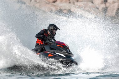 Profesyonel atlet, okyanus dalgalarında yüksek hızda bir su aracına biniyor.