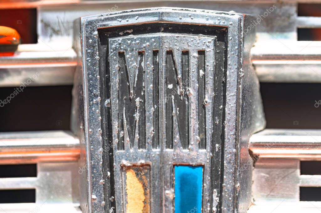 Larnaca, Cyprus- May 12, 2024: Classic MINI logo on a vintage car, displaying signs of aging and weathering, capturing automotive history