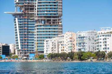 Kıbrıs Rum Kesimi 'nin Limasol kıyı şeridinde inşa halindeki modern gökdelen daha küçük konut binalarının üzerine inşa ediliyor.