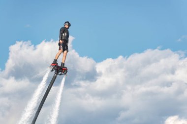 Sinek sörfçüsü dramatik bulutlara karşı etkileyici gösteriler sergiliyor, heyecan verici bir su sporunda yetenek ve adrenalin sergiliyor.