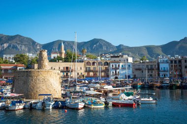 Kıbrıs Rum Kesimi 'nin tarihi şatosu, sayısız tekne ve arka planda çarpıcı bir dağ sırasının yer aldığı Kyrenia limanının manzarası.