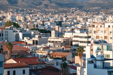 Kıbrıs 'taki Limasol' un modern şehir manzarası arka planda binaları ve dağları gösteriyor