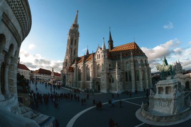 Budapeşte, Macaristan - 02 Ocak 2019: Turistler gün batımında Budapeşte 'deki Matthias Kilisesi' ni ziyaret edecekler ve önplanda Kral Stephen 'ın binicilik heykeli var.