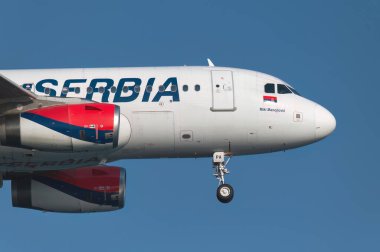 Larnaca, Kıbrıs - 29 Haziran 2024: Air Serbia Airbus A319 Miki Manojloviç iniş takımları aşağı ve arkadaki mavi gökyüzü ile iniyor