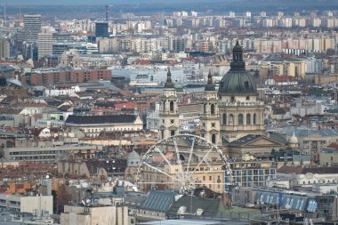 Macaristan 'ın Budapeşte şehrinde arka planda Aziz Stephen' ın bazilikası olan dönme dolap duruyor.