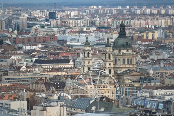 Macaristan 'ın Budapeşte şehrinde arka planda Aziz Stephen' ın bazilikası olan dönme dolap duruyor.