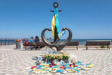 Larnaca, Kıbrıs - 17 Nisan 2023: Ukrayna bayrağıyla büyük çapa ve savaş kurbanlarının anısına boyanmış taşlar