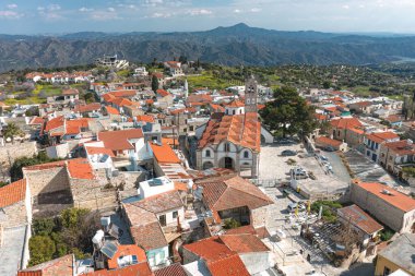 Kıbrıs 'taki Lefkara köyünde kırmızı kiremitli çatılar, önemli bir kilise ve kayan dağlar yer alıyor.