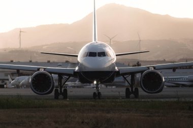 Modern yolcu uçağı Larnaca Havaalanı 'nda gün batımında bir pistte bekliyor. Kıbrıs