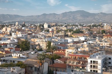 Sıcak öğleden sonra güneşi Lefkoşe, Kıbrıs 'ın evleri ve binaları üzerinde parlıyor