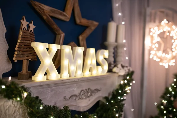 Winter, holidays and decoration concept - Christmas decorations and Xmas letters over sparkling holiday lights