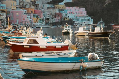 View of the Port of Corricella with lots of colorful houses on a sunny day in Procida Island, Italy.