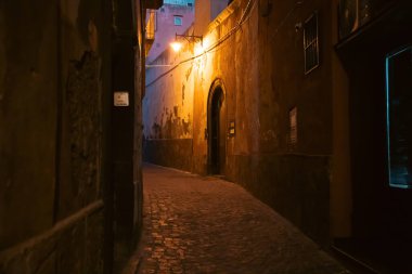 Tiny narrow streets with colorful houses at night on Procida Island, Italy.