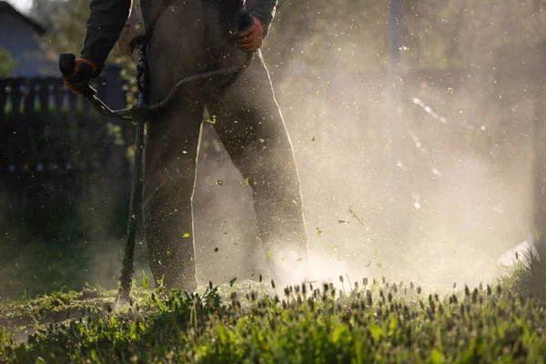 stock image Mowing the grass with a lawn mower. Garden work concept background.