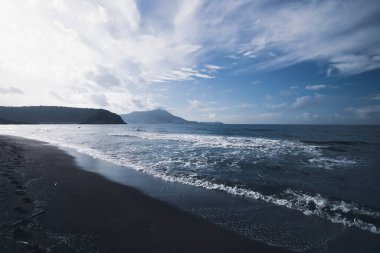 View of Ciraccio beach with black sand and clear water, Procida, Italy clipart