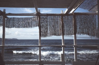 Cozy terrace on the beach, idyllic view of the seashore. Tropical summer vacation concept.