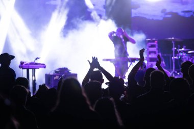 Konserde kalabalık - Parlak renkli sahne ışıkları önünde tezahürat yapan kalabalık