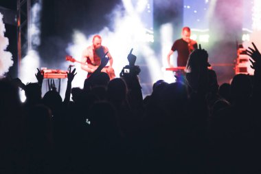 Konserde kalabalık - Parlak renkli sahne ışıkları önünde tezahürat yapan kalabalık