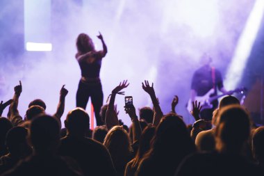 Konserde kalabalık - Parlak renkli sahne ışıkları önünde tezahürat yapan kalabalık