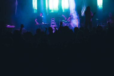 Konserde kalabalık - Parlak renkli sahne ışıkları önünde tezahürat yapan kalabalık