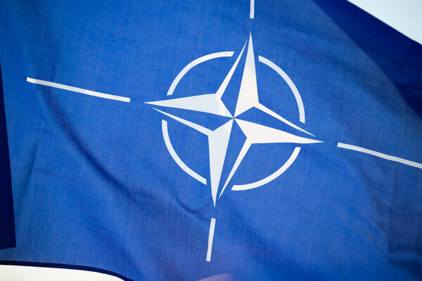 NATO (North Atlantic Treaty Organization) flag waving. NATO is an international military alliance that constitutes a system of collective security