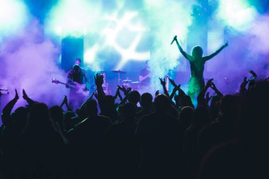 Konserde kalabalık - Parlak renkli sahne ışıkları önünde tezahürat yapan kalabalık