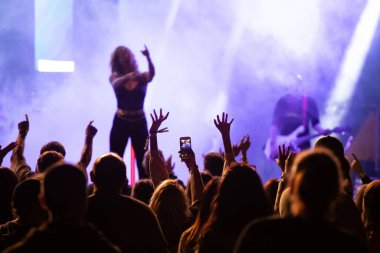 Konserde kalabalık - Parlak renkli sahne ışıkları önünde tezahürat yapan kalabalık