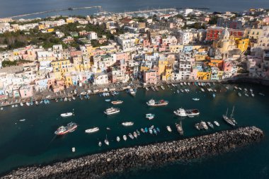 View of the Port of Corricella with lots of colorful houses on a sunny day in Procida Island, Italy.