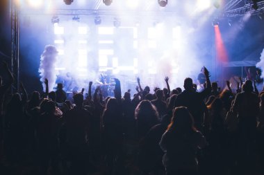 Konserde kalabalık - Parlak renkli sahne ışıkları önünde tezahürat yapan kalabalık
