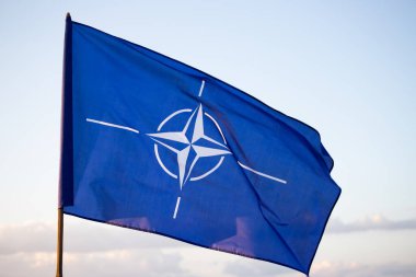 NATO (North Atlantic Treaty Organization) flag waving. NATO is an international military alliance that constitutes a system of collective security