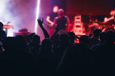 Konserde kalabalık - Parlak renkli sahne ışıkları önünde tezahürat yapan kalabalık