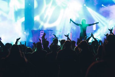 Konserde kalabalık - Parlak renkli sahne ışıkları önünde tezahürat yapan kalabalık