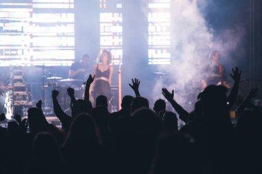 Konserde kalabalık - Parlak renkli sahne ışıkları önünde tezahürat yapan kalabalık