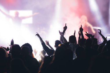 Konserde kalabalık - Parlak renkli sahne ışıkları önünde tezahürat yapan kalabalık