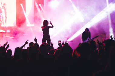 Konserde kalabalık - Parlak renkli sahne ışıkları önünde tezahürat yapan kalabalık