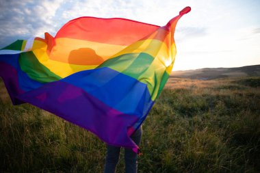 Woman holding a Gay Rainbow Flag.Happiness, freedom and love concept for same sex couples